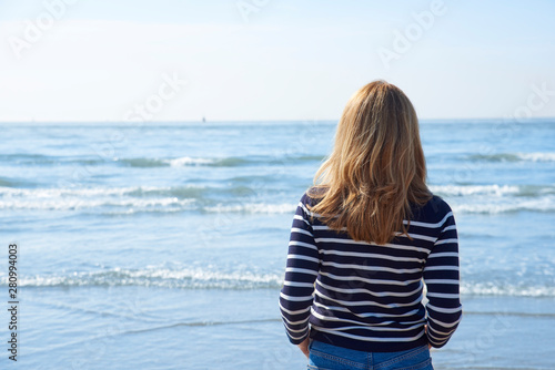 Rear view shot of woman standing on the beach