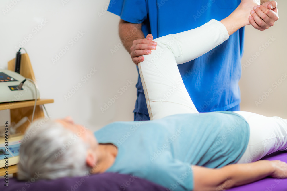 Physical Therapist Working with Leg. Senior Woman Physical Therapist Working with Leg. Senior Woman