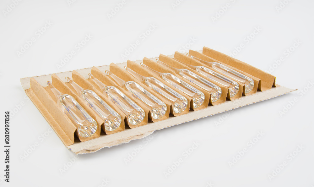 Glass ampoules in packing box on white background. Glass ampoules in packing box on white background.