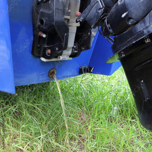 Drain bilge water through the drain scupper on transom motor boat with outboard motor