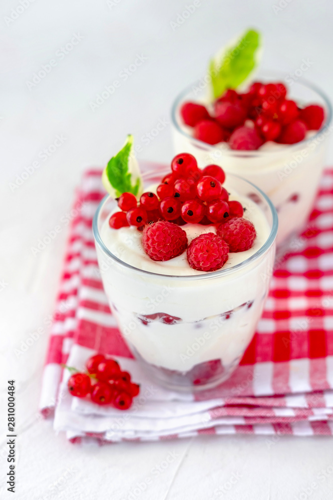 Two glasses with greek yogurt, raspberry and red currant Two glasses with greek yogurt, raspberry and red currant