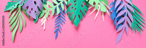 Fototapeta tropikalne liście wycięte z papieru na różowym tle.