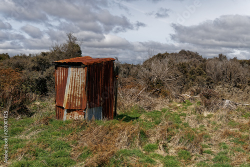 A rusty corrugated iron back country toilet or outhouse. photo