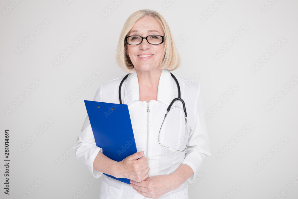 Woman in a white medical clothes and glasses standing isolated on a blue background Woman in a white medical clothes and glasses standing isolated on a blue background