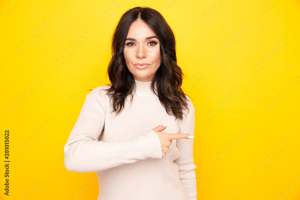 Woman in theyellow studio pointing something by her finger Woman in theyellow studio pointing something by her finger