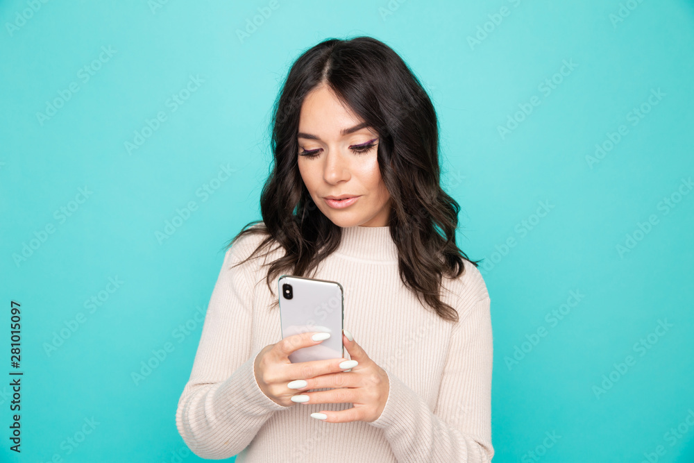 Smiling woman with airpods and mobile isolated in the blue studio Smiling woman with airpods and mobile isolated in the blue studio