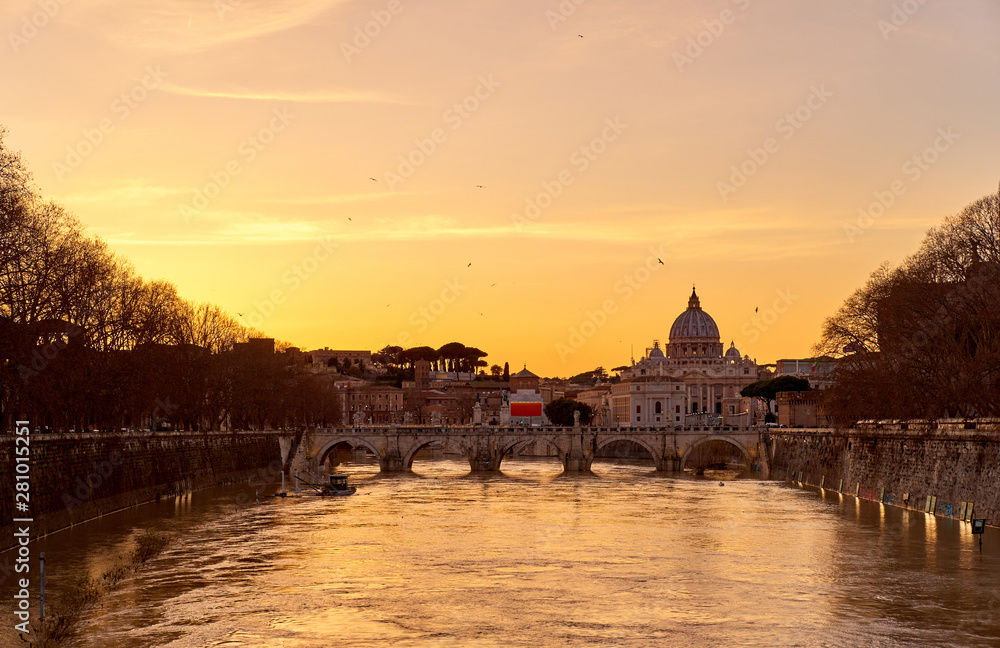 St. Peter's cathedral and Tiber river with high water at  sunset. Saint Peter Basilica in Vatican city with Saint Angelo Bridge in Rome, Italy