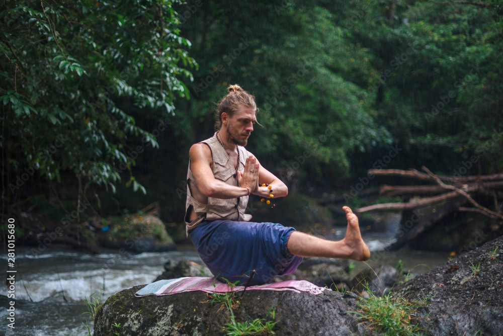 Yoga practice and meditation in nature. Man practicing near river Yoga practice and meditation in nature. Man practicing near river
