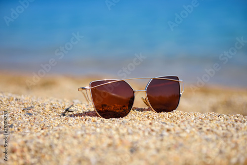 Sunglasses on the beach near sea on a hot sunny day. Summer vacation concept