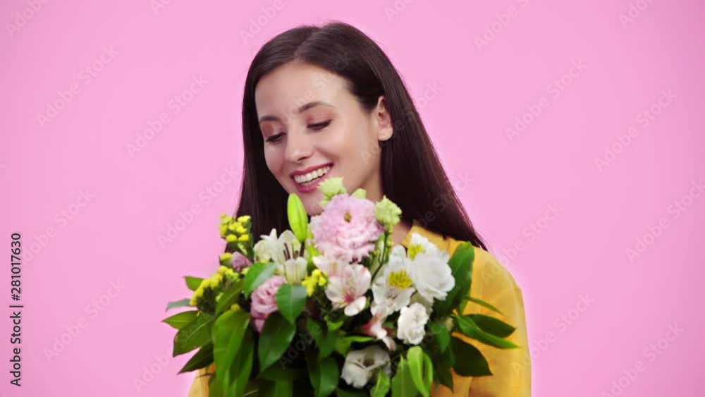 beautiful girl sniffing flowers, looking at camera and smiling Isolated On pink beautiful girl sniffing flowers, looking at camera and smiling Isolated On pink
