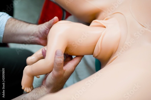 Simulation of complicated breech birth on mannequin childbirth s photo