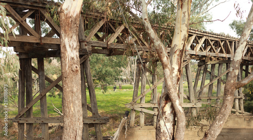 old timber hardwood discontinued railway bridge river crossing in a rural farming town, Victoria, Australia © fieldofvision