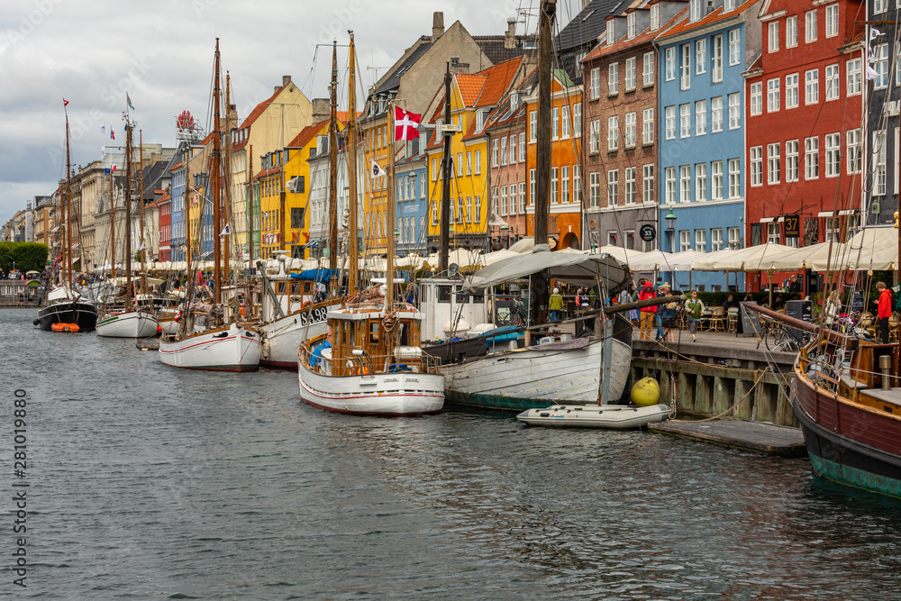 Scenic summer view of Nyhavn pier with color buildings, ships, yachts and other boats in the Old Town of Copenhagen, Denmark.