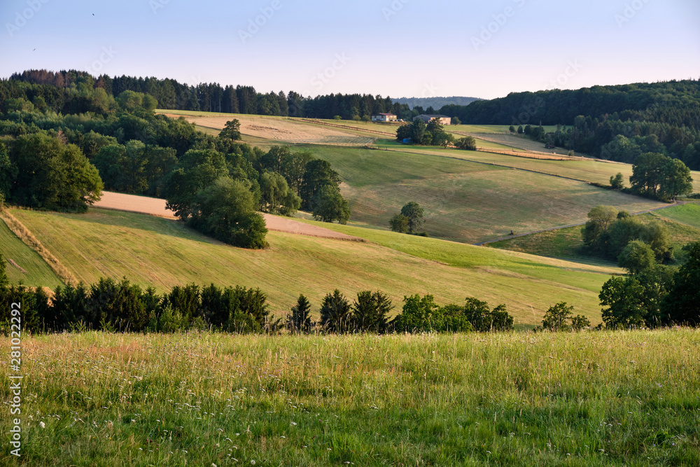 Beautiful evening landscape in the Spessart area in Germany with trees, hills and agricultural fields