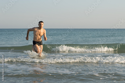 A man runs through the waves at sea