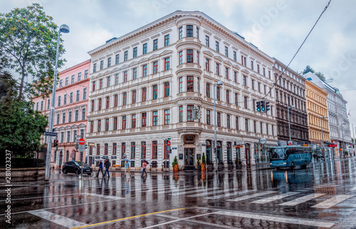 Rainy day in Vienna, Austria. Wet streets, puddles, pedestrians with umbrellas and public transport