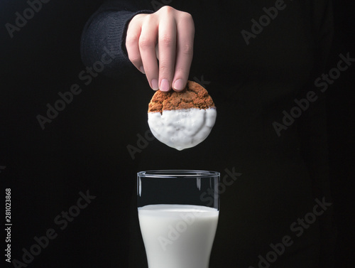  Cookies in a hand over a glass of milk