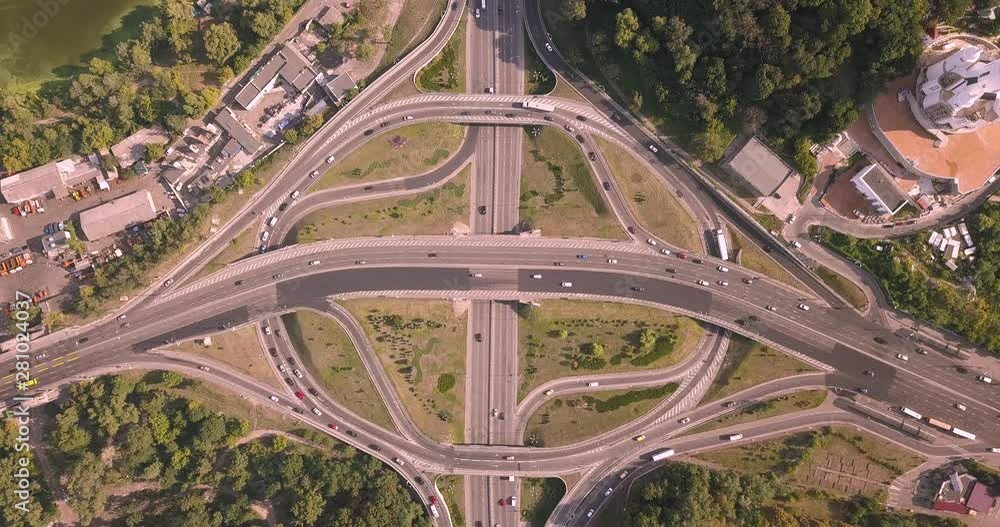 Aerial high drone in 4K flight over evening road traffic in Kiev, Ukraine. Highway and overpass with cars and trucks, interchange, two-level road junction in the big city. Top view. Aerial high drone in 4K flight over evening road traffic in Kiev, Ukraine. Highway and overpass with cars and trucks, interchange, two-level road junction in the big city. Top view.