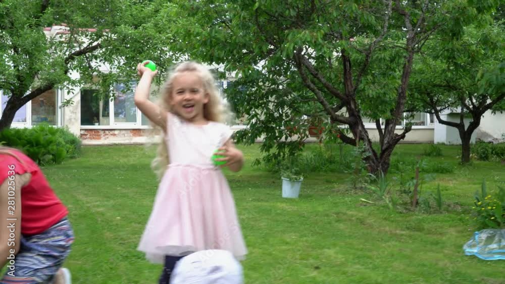 Caucasian children with mother throwing balls into camera. Gimbal movement Caucasian children with mother throwing balls into camera. Gimbal movement