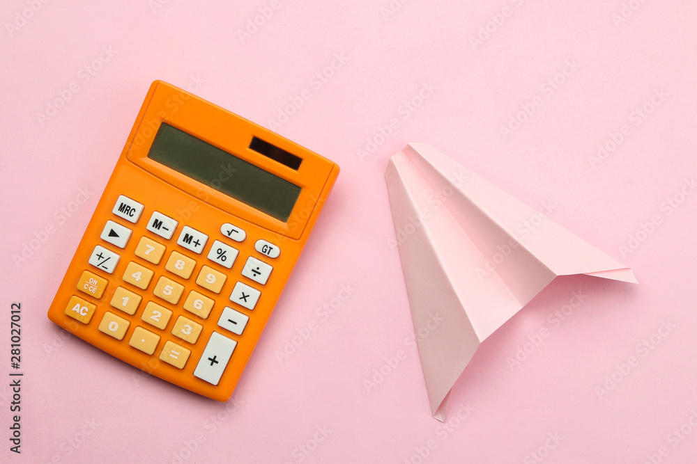 Orange calculator and paper airplane on a bright pink paper background. Office supplies. Education. back to school. top view. Orange calculator and paper airplane on a bright pink paper background. Office supplies. Education. back to school. top view.
