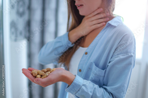 Fotografie Young woman suffers from choking and cough from allergic reaction to peanut
