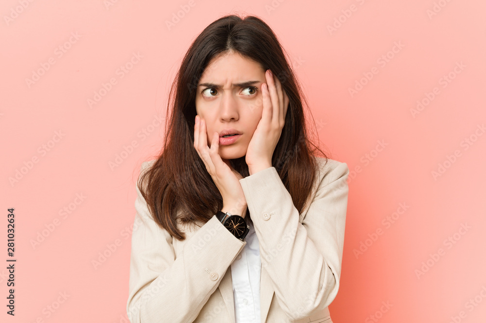 Young brunette business woman against a pink background whining and crying disconsolately. Young brunette business woman against a pink background whining and crying disconsolately.
