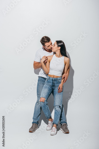 full length view of young man hugging girlfriend from back