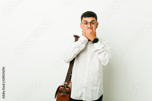 Young hispanic casual business man shocked covering mouth with hands.