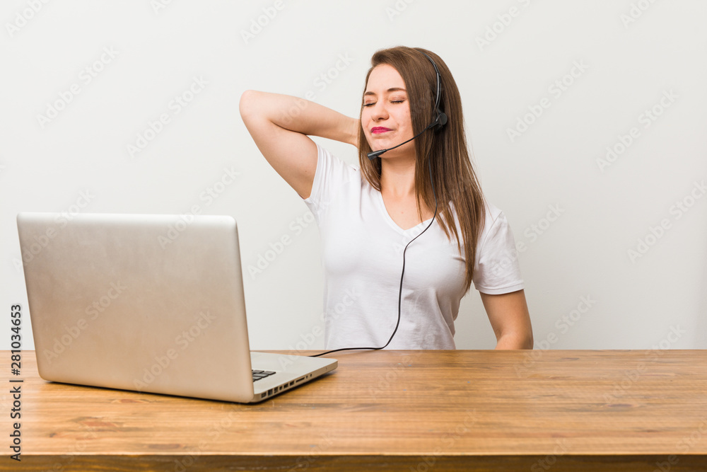 Young telemarketer woman suffering neck pain due to sedentary lifestyle.