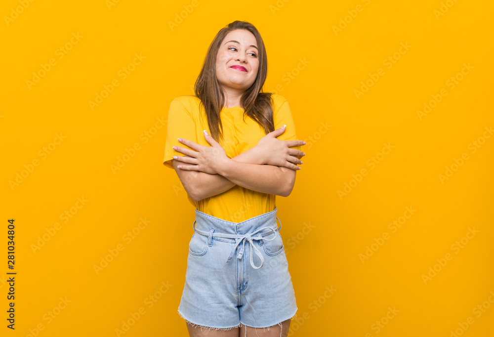 Young woman teenager wearing a yellow shirt hugs, smiling carefree and happy. Young woman teenager wearing a yellow shirt hugs, smiling carefree and happy.