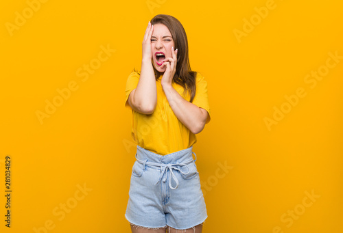 Young woman teenager wearing a yellow shirt whining and crying disconsolately. © Asier