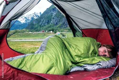 girl sleeps in sleepbag in the tent
