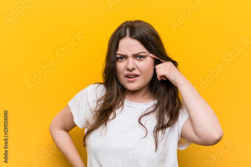 Young curvy plus size woman showing a disappointment gesture with forefinger.