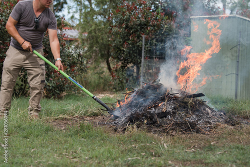 Man tending to fire controlled burn off of garden waste