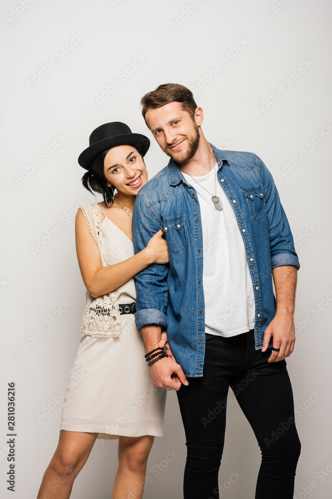 young couple in stylish clothes hugging, smiling and looking at camera young couple in stylish clothes hugging, smiling and looking at camera