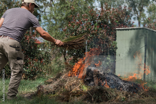 Man tending to fire controlled burn off of garden waste