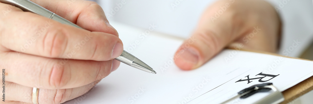 Male doctor arm filling out prescription form Male doctor arm filling out prescription form