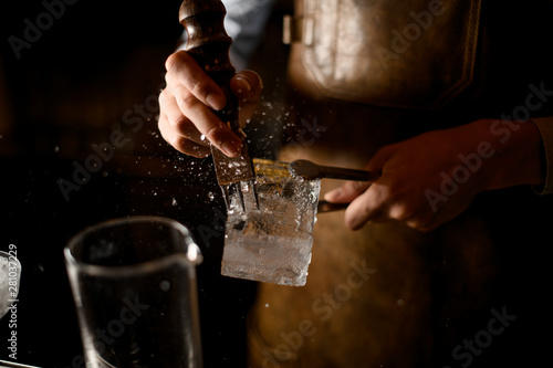 Close-up of bartender crushing the ice cube