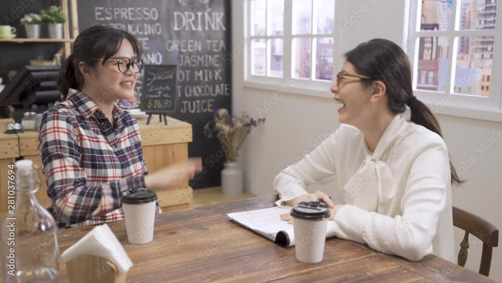 young Asian professional woman in interview meeting. woman interviewer laughing out loud naturally while listen fresh graduate girl candidate talk describing introducing herself humorous in cafe bar young Asian professional woman in interview meeting. woman interviewer laughing out loud naturally while listen fresh graduate girl candidate talk describing introducing herself humorous in cafe bar