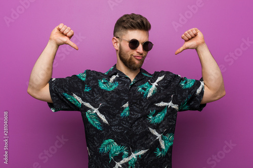 Young man wearing a vacation look feels proud and self confident, example to follow.