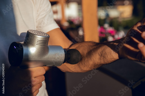 Boy massaging with machine to massage body at sunset photo