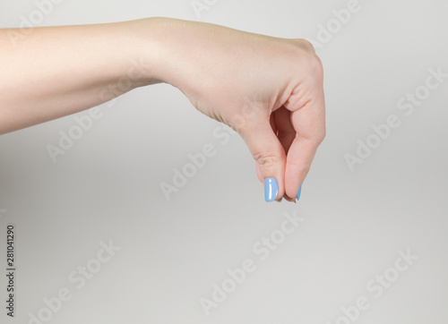 Female hand making pinch gesture holding something virtual and invisible. Horizontal color photography.