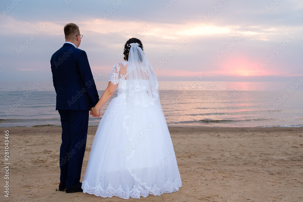 Groom and bride standing side by side on the background of the sea, at the sea side in hawaii Groom and bride standing side by side on the background of the sea, at the sea side in hawaii