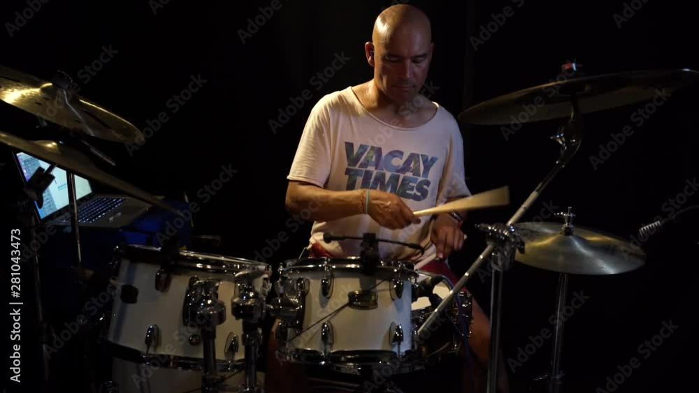 Medium shot of a drummer playing his drumkit while he sweats a lot. Medium shot of a drummer playing his drumkit while he sweats a lot.