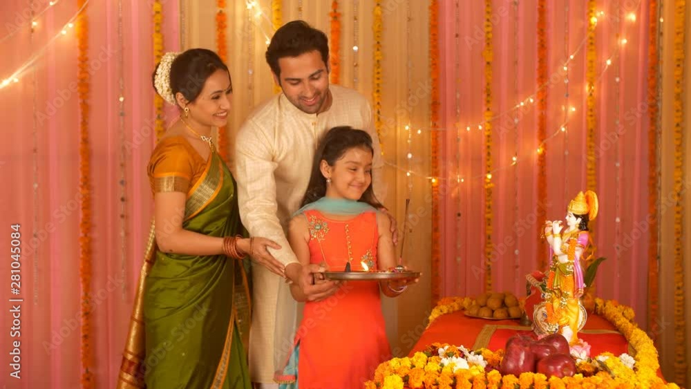 Indian Nuclear family worshiping Lord Krishna with Puja Thali Love