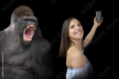 Attractive, daring young girl taking a selfie with a gorilla