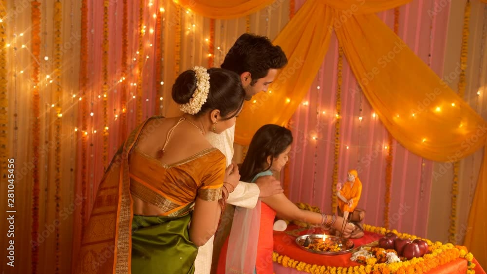 Indian nuclear family worshiping Indian Spiritual Master Sai Baba