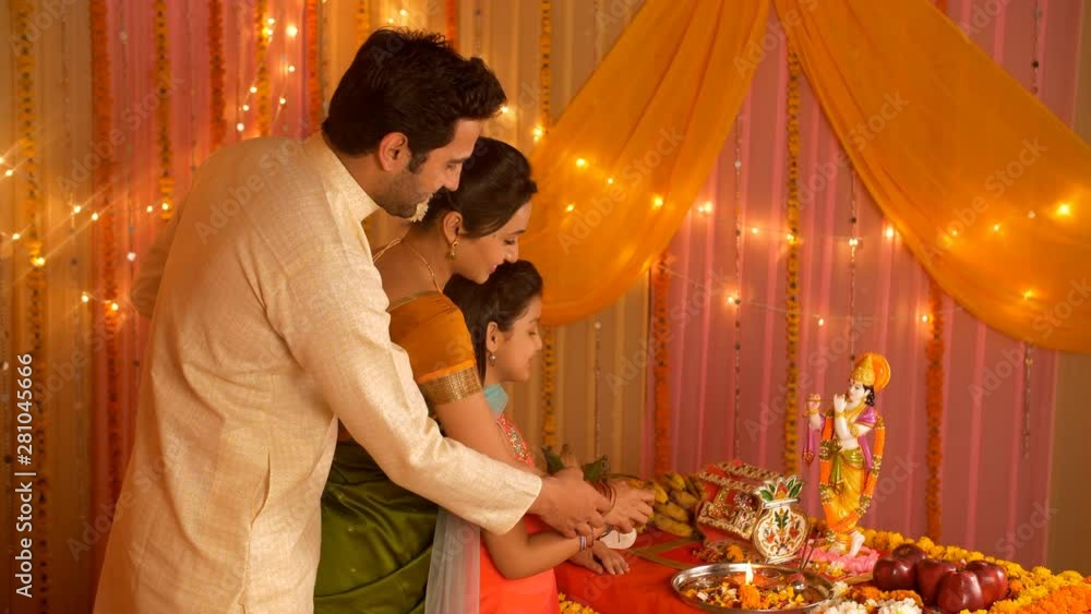 Happy Indian family performing Hindu rituals on the auspicious day of