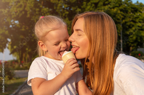 Young mother and daughter eat one ice cream.