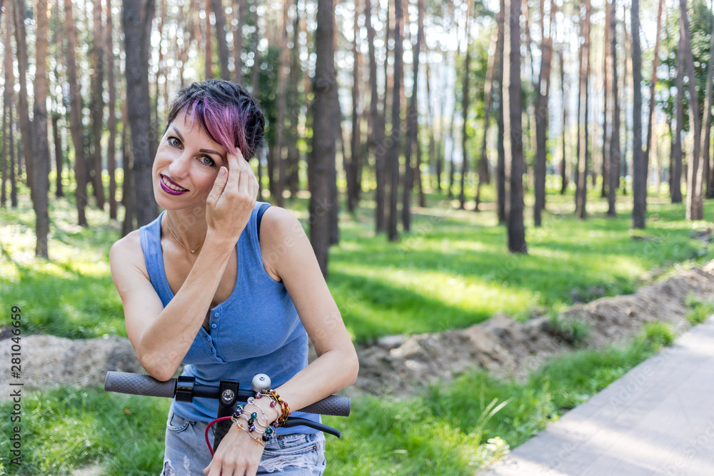 Cool attractive woman with pink hair, enjoys riding an electric scooter. Cool attractive woman with pink hair, enjoys riding an electric scooter.